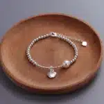 Bracelet perle blanche pendentif coeur acier 1